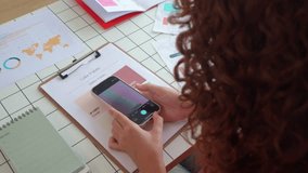 Professional graphic designer selecting color palette using digital color picker app on modern smartphone while working on creative project - Powered by Shutterstock - Get 15% off with code: PIKWIZARD15