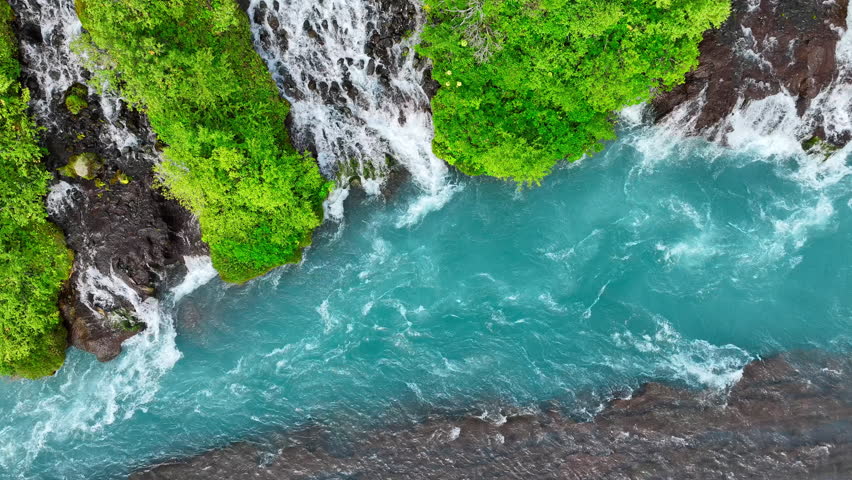 Summer Waterfall with Many small streams flow from the lava field. River with the purest glacial water of turquoise blue color