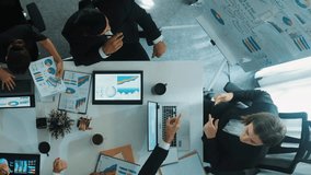 Top down aerial view of smart manager pointing at financial graph on whiteboard while diverse business team explain and plan marketing idea at meeting table with stock market statistic. Directorate. - Powered by Shutterstock - Get 15% off with code: PIKWIZARD15
