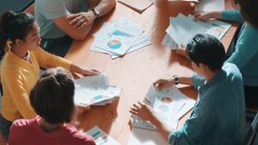 Top down view of start up business team holding paper while discussing about financial idea. Aerial view of smart diverse people brainstorming idea while looking at stock market statistic. Symposium. - Powered by Shutterstock - Get 15% off with code: PIKWIZARD15