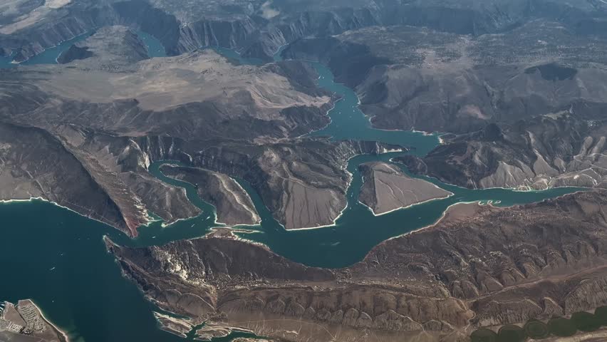 4k aerial video footage flying along "Green River" in Flaming Gorge National Recreation Area, at border between Wyoming and Utah near city of Manila, UT with Flaming Gorge Dam surrounded by Canyons
