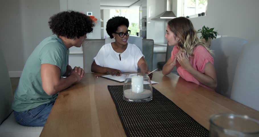 African American consultant opening binder at home, couple signing closing papers and shaking hands. Professional, consultation, agreement, partnership, negotiation, modern, welcoming