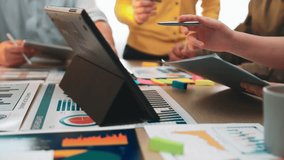 A group of professionals collaborating in a modern office environment, using digital devices and presentation materials for effective business strategy and data analysis. SACTR - Powered by Shutterstock - Get 15% off with code: PIKWIZARD15