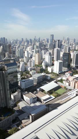 Aerial view of Bangkok city skyline, Thailand. Modern skyscrapers, business towers, and urban buildings under clear blue sky in Southeast Asia