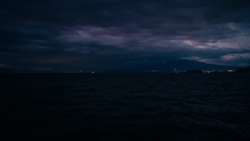 Japanese Mountain Horizon Over Ocean – Cloudy twilight sky reflects over calm seascape.