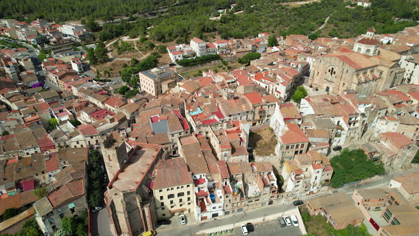 Tilt up aerial shot Mont-roig del Camp town on sunny summer day. Tarragona, Spain.