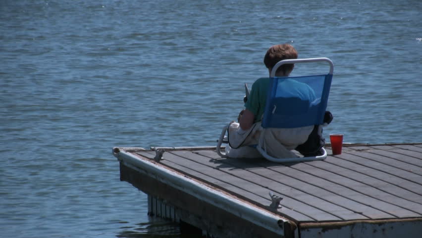 Woman reads a book on dock tight shot