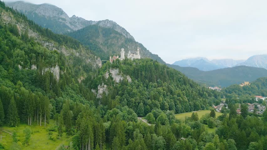 Marvel at the stunning sights of Neuschwanstein Castle nestled in the Bavarian mountains. The morning light highlights its majestic structure and beautiful surroundings, offering breathtaking scenery.