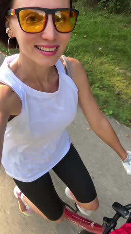 Smiling Woman Riding Bicycle Outdoors in Summer, POV Selfie View, Healthy Active Lifestyle and Fitness Concept  