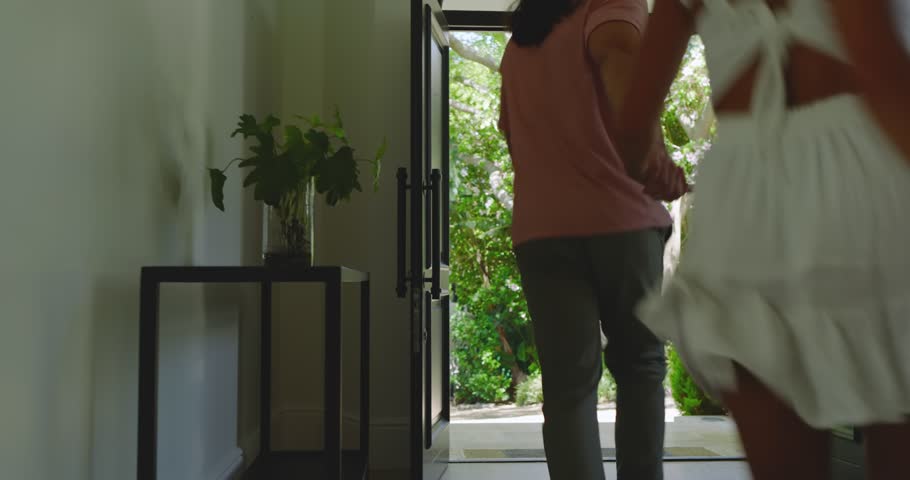Couple stepping through garden door pausing while man kneeling placing engagement ring and hugging. Romance, proposal, celebration, affection, intimacy, joy, elegance