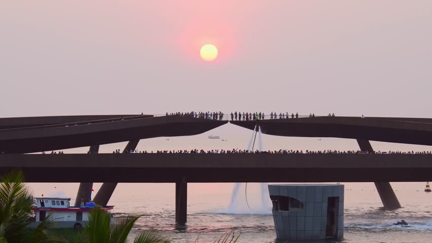 Crowd of visitors tourist on Kiss bridge during water show on Sunset town in Phu Quoc, Vietnam. Hoverboard show performance in public