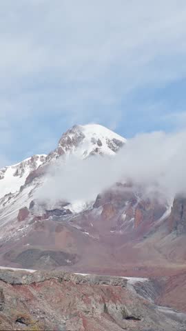 Stepantsminda, Gergeti, Georgia. Peak Of Mount Kazbek Covered Snow In Winter Landscape. vertical, vertical footage, vertical video