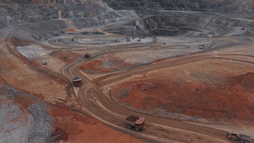 Dump truck is transporting gold and copper ore into in open pit mine, mining industry Aerial view.