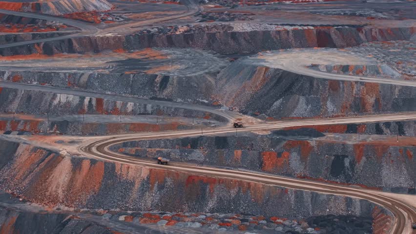 Big yellow mining trucks lifts along road Aerial view. Open pit mine of gold, copper ore, dumpers, quarrying extractive industry stripping work.