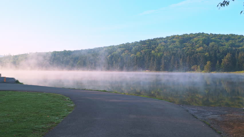 Spruce Knob Lake in Appalachian mountains West Virginia, sunrise morning fog above water in Monongahela National Forest pov point of view walking