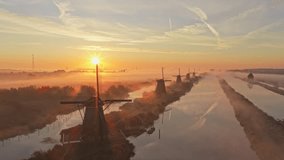 Misty sunrise scene showing scenic countryside sunrise at kinderdijk windmills, atmospheric fog, holland. A tranquil travel view of Dutch windmills and canals. - Powered by Shutterstock - Get 15% off with code: PIKWIZARD15