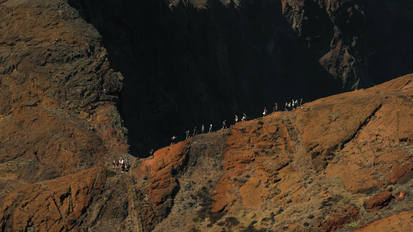 Group of Hikers Walking Along Rocky Mountain Trail in Madeira