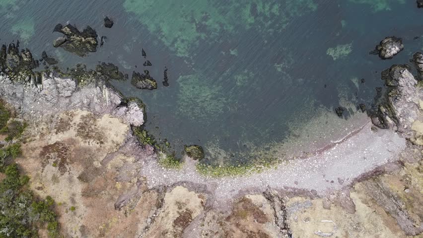 Calm water in North america beach Aerial drone top down view bird eye view of sea waves break on the rock.