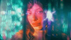 Young beautiful woman with glitter makeup posing for camera surrounded by colorful glowing lights against shimmering background. Video portrait - Powered by Shutterstock - Get 15% off with code: PIKWIZARD15