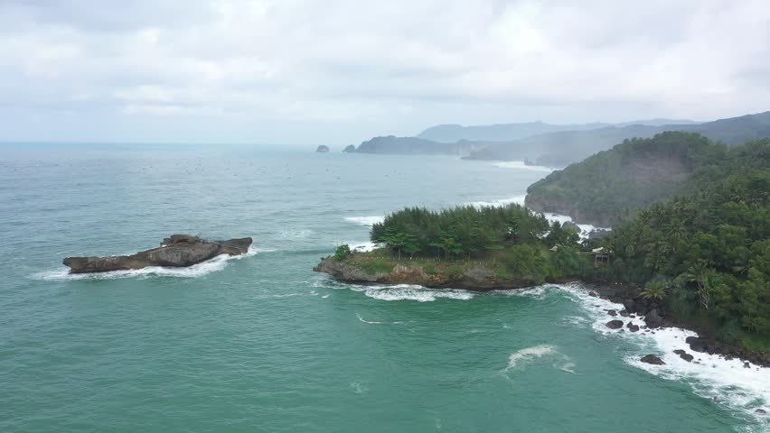 Drone shoot of Watu Bale beach in Pacitan with a bridge that stretches connecting the small island with the rocks like on Timang beach in Yogyakarta