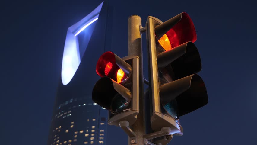 Traffic lights with Kingdom Tower in Riyadh, Saudi Arabia at night
