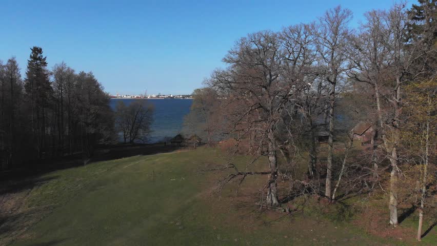 A picturesque and scenic view of the calm lake surrounded by beautiful trees and ancient structures