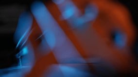 A dramatic close-up rack focus reveals the wooden bridge and strings of a cello. Moody blue and orange light creates a cinematic atmosphere against a dark background. - Powered by Shutterstock - Get 15% off with code: PIKWIZARD15