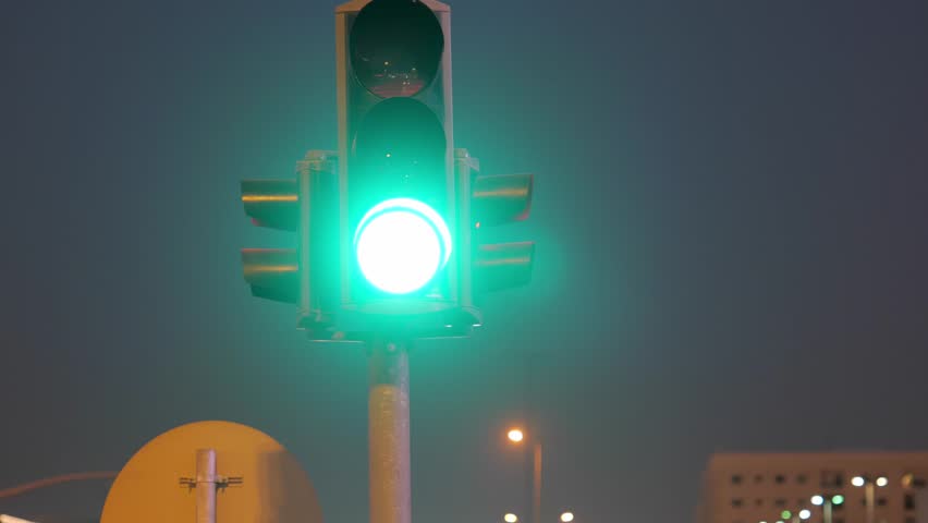 Traffic lights with Kingdom Tower in Riyadh, Saudi Arabia at night