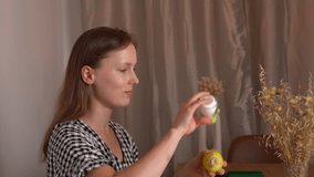 A young woman salts and eats boiled corn on the cob in the living room, side view. Concept of home food, healthy eating, vegetables, organic snack, natural diet, lifestyle. - Powered by Shutterstock - Get 15% off with code: PIKWIZARD15