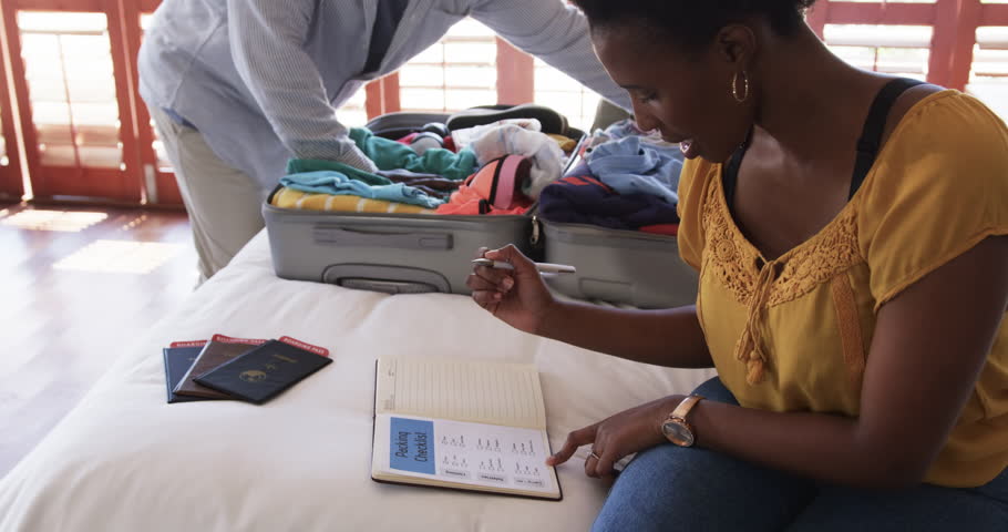 Family packing suitcase on bed, preparing for vacation with passports ready, at home. Travel, luggage, journey, planning, family trip, holiday