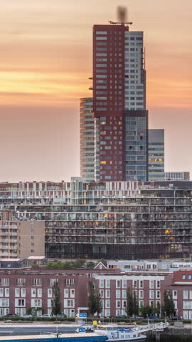 Aerial day to night transition timelapse of Katendrecht peninsula and Maashaven harbour in Rotterdam, The Netherlands. City skyline modern skyscrapers and traditional Dutch waterfront houses