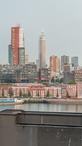 Panoramic aerial timelapse of Katendrecht peninsula and Maashaven harbour in Rotterdam, The Netherlands. City skyline at morning, modern skyscrapers and former factory with Dutch waterfront houses