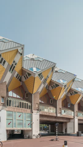 Hyperlapse of Cube House (Kubuswoningen) in Rotterdam. Unique yellow cube-shaped houses showcasing innovative architecture amid the cityscape timelapse. Blue sky and urban vibrancy. Netherlands