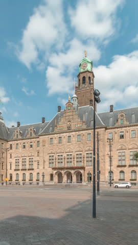 Hyperlapse of Rotterdam City Hall (Stadhuis van Rotterdam) at Coolsingel. One of the few historic buildings in the city center timelapse. Traffic and people on the street, cloudy blue sky. Netherlands