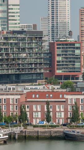 Aerial timelapse of modern buildings in Rotterdam city center, The Netherlands. Towers and skyscrapers in the financial district with warm morning light creating a vibrant skyline. Ships on waterfront