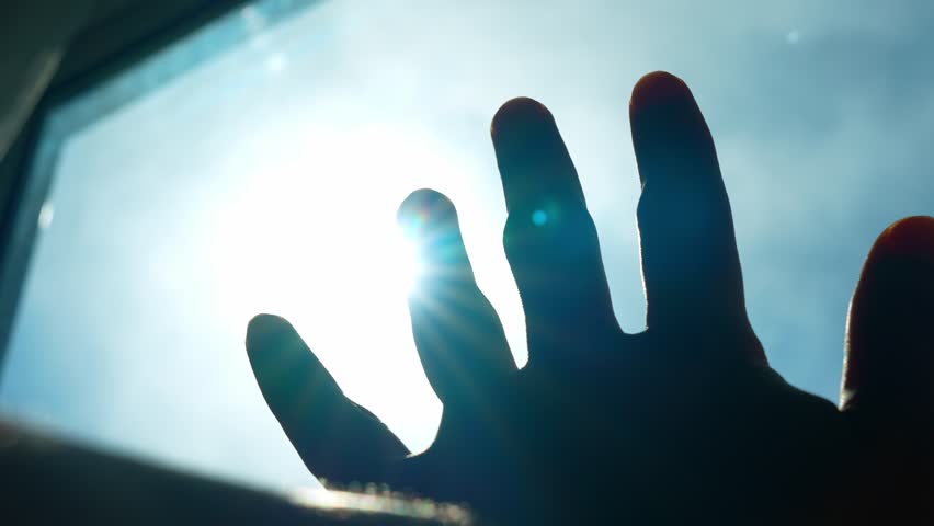 A hand filters the blazing noon sunlight, demonstrating the quest for relief, self-care, and thoughtful adjustment. This act suggests mindfulness, control, health consciousness, and resourcefulness.
