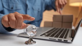 A hand spins a globe while the other arranges e-commerce packages on a laptop, symbolizing global trade, online shopping, worldwide logistics, digital entrepreneurship, and cross-border commerce.
 - Powered by Shutterstock - Get 15% off with code: PIKWIZARD15