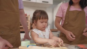 Asian mature parents lovingly care for and raises baby girl at home. Attractive couple shares tender moment teaching daughter toddler baking bakery in cozy kitchen, creating warm and nurturing family. - Powered by Shutterstock - Get 15% off with code: PIKWIZARD15