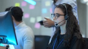 A diverse team of customer support agents works in a modern call center. Smiling operators assist clients over the phone, providing helpful and professional technical support. - Powered by Shutterstock - Get 15% off with code: PIKWIZARD15