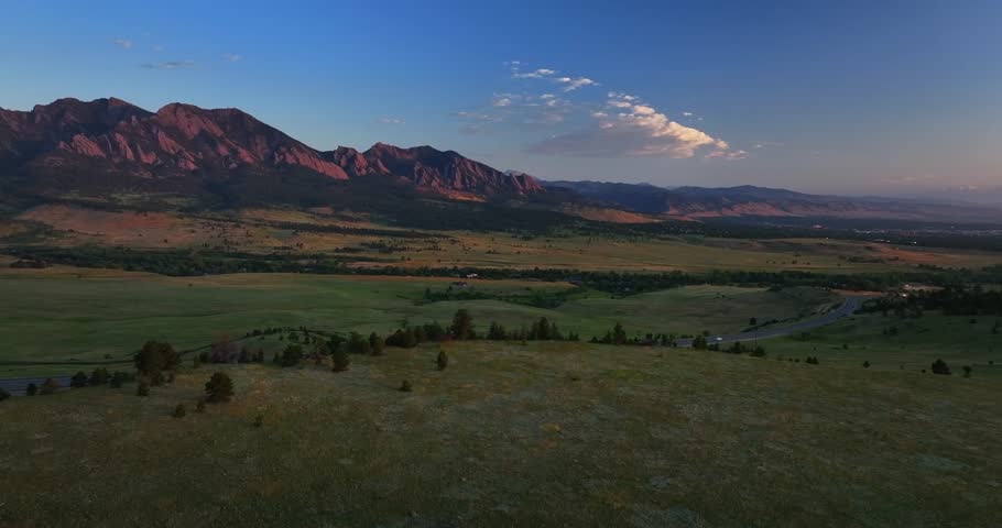 Flatirons Front Range Boulder Chautauqua Park morning sunrise aerial drone Colorado spring summer pink cloud first light on red slanted Rocky Mountains highway 36 car traffic Boulder Turnpike upwards