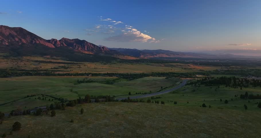 Flatirons Front Range Boulder Chautauqua Park morning sunrise aerial drone Colorado spring summer pink cloud first light on red slanted Rocky Mountains highway 36 car traffic circle right