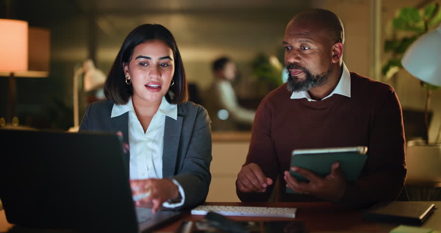 Tablet, laptop and teamwork with business people in office for night, planning and budget report. Tax audit, online review and submission deadline with employees in finance agency for advice