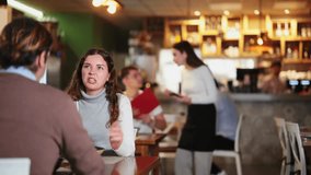 Smiling woman in warm clothes sitting with a glass of red wine and talking to man in a cozy restaurant. Romantic dinner for a couple in a European restaurant - Powered by Shutterstock - Get 15% off with code: PIKWIZARD15