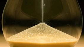 An hourglass, or a clock with sand flowing out of it, is a symbol of the passage of time. It can be used to measure time. Symbol, concept, time out, hour. - Powered by Shutterstock - Get 15% off with code: PIKWIZARD15