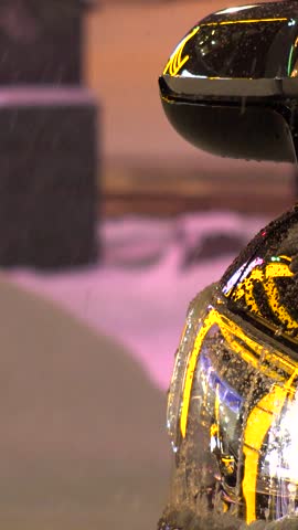 SAPPORO, HOKKAIDO, JAPAN - FEB 2020 : Snow scenery around Susukino city area at night. Soft snow falling at downtown street. Japanese winter and cold snowing season concept vertical video.