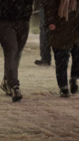 SAPPORO, HOKKAIDO, JAPAN - FEB 2020 : Snow scenery around Susukino city area at night. Soft snow falling at downtown street. Japanese winter and cold snowing season concept vertical video.