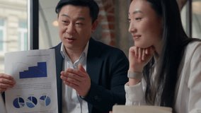 Two Asian business people team showing financial marketing data video call talking with laptop document in office together Chinese coworkers Japanese colleagues businesswoman businessman teamwork - Powered by Shutterstock - Get 15% off with code: PIKWIZARD15