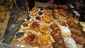 A display case in a supermarket with a variety of puff pastry including croissants and other puff pastry with various fillings. The display case features various puff pastry buns and pastries. - Powered by Shutterstock - Get 15% off with code: PIKWIZARD15