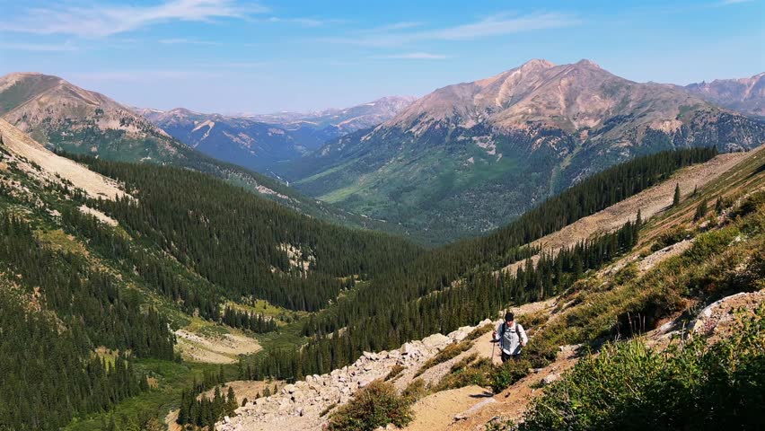 Hiker hiking La Plata Peak Gulch Trail 14er view of Independence Pass Sawatch Range 14er spring summer Rocky Mountains Colorado high alpine elevation treeline morning blue sky haze static shot