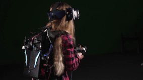 A teenage girl wearing a VR headset, immersed in virtual reality, in a game studio. She is circling around herself and watching a video with glasses. A new generation of headset for entertainment. - Powered by Shutterstock - Get 15% off with code: PIKWIZARD15